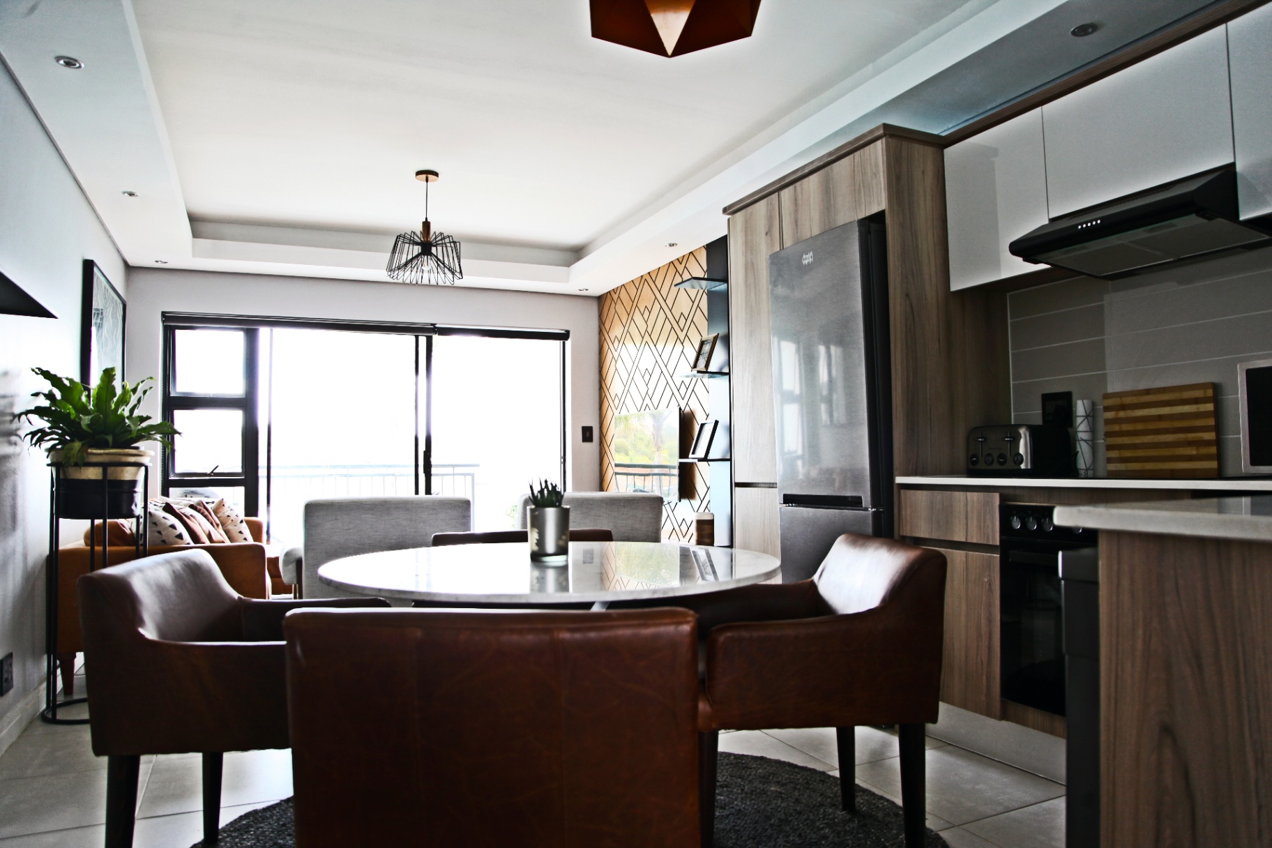 Open plan dining area with marble table and leather chairs