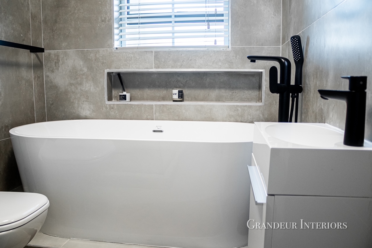 Bathroom with freestanding tub, matte black fittings and concrete-look tiles