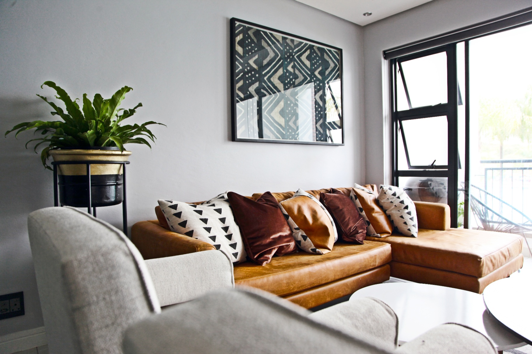 Lounge detail featuring layered cushions and textile artwork